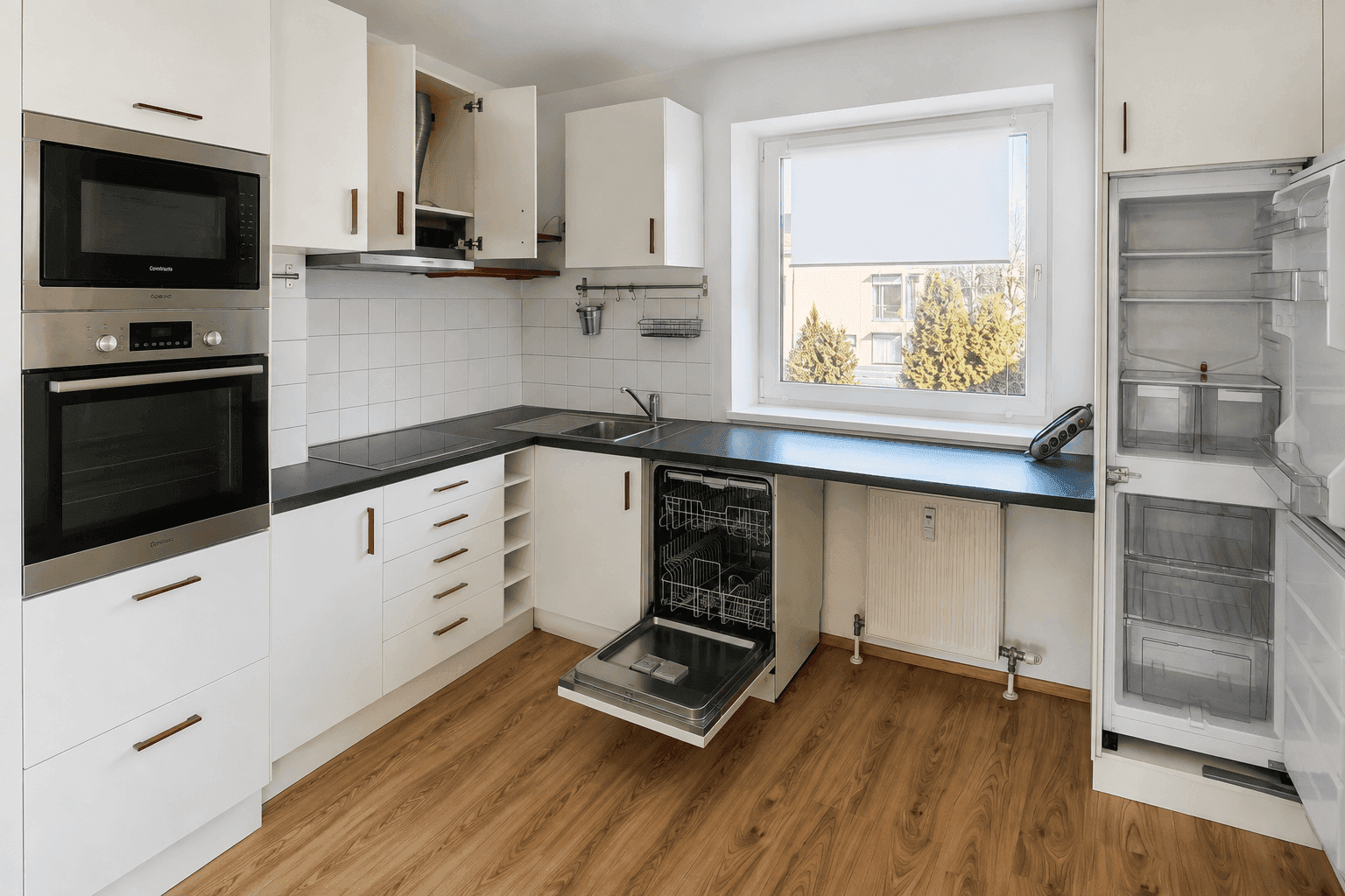 Moderne weiße Einbauküche mit integrierten Geräten, dunkler Arbeitsplatte und Fenster.