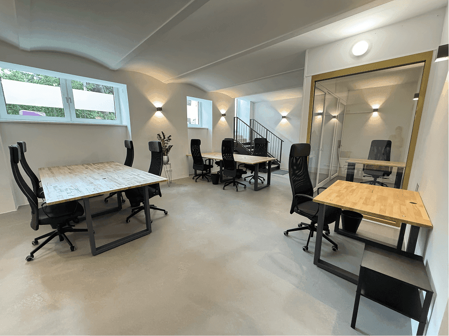 Weitläufiger Bürobereich mit mehreren Arbeitsplätzen, Glaswänden und moderner Beleuchtung.