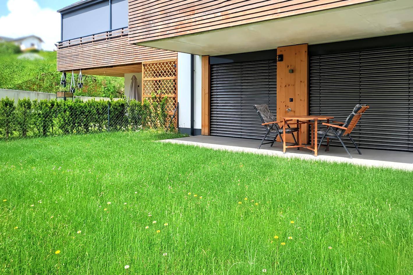 Gepflegter Gartenbereich mit Rasenfläche und kleiner Terrasse für entspannte Stunden im Freien.