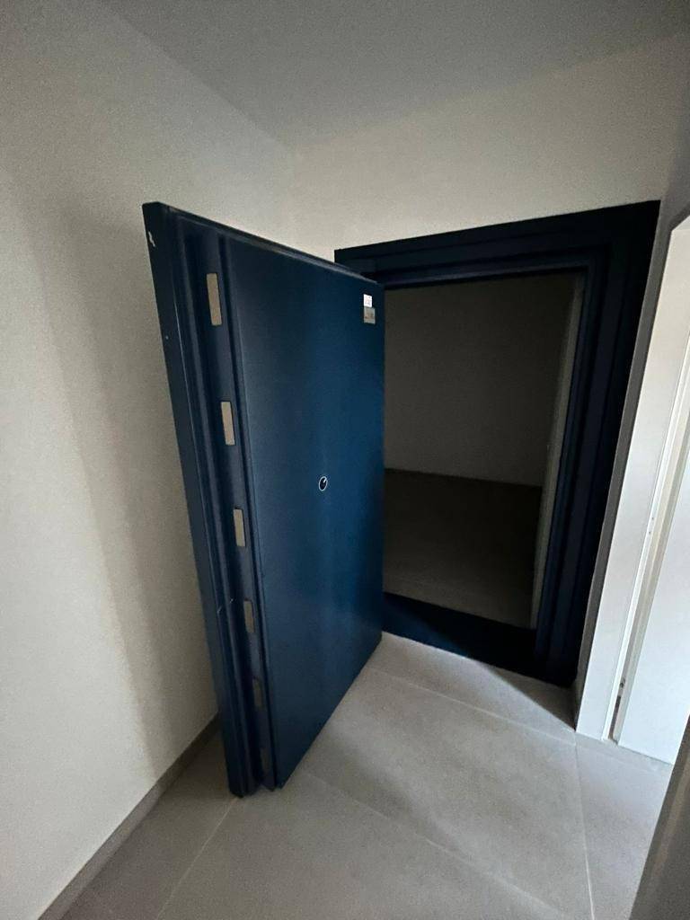 Schwerer Tresorraum mit massiver blauer Stahltür, der einen sicheren Lagerbereich für Wertsachen schützt.