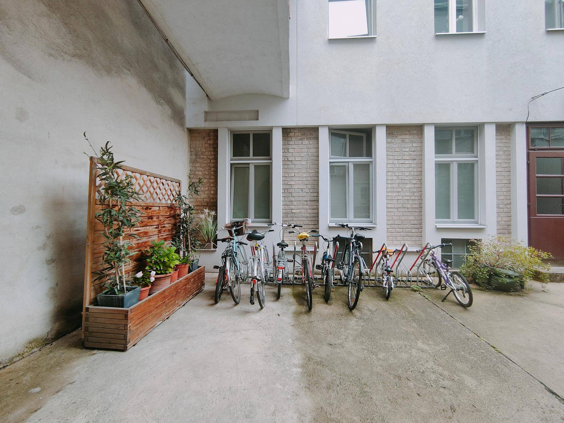 Innenhof mit Fahrradabstellplätzen und der Fassade eines Wohngebäudes, das viel Platz bietet.