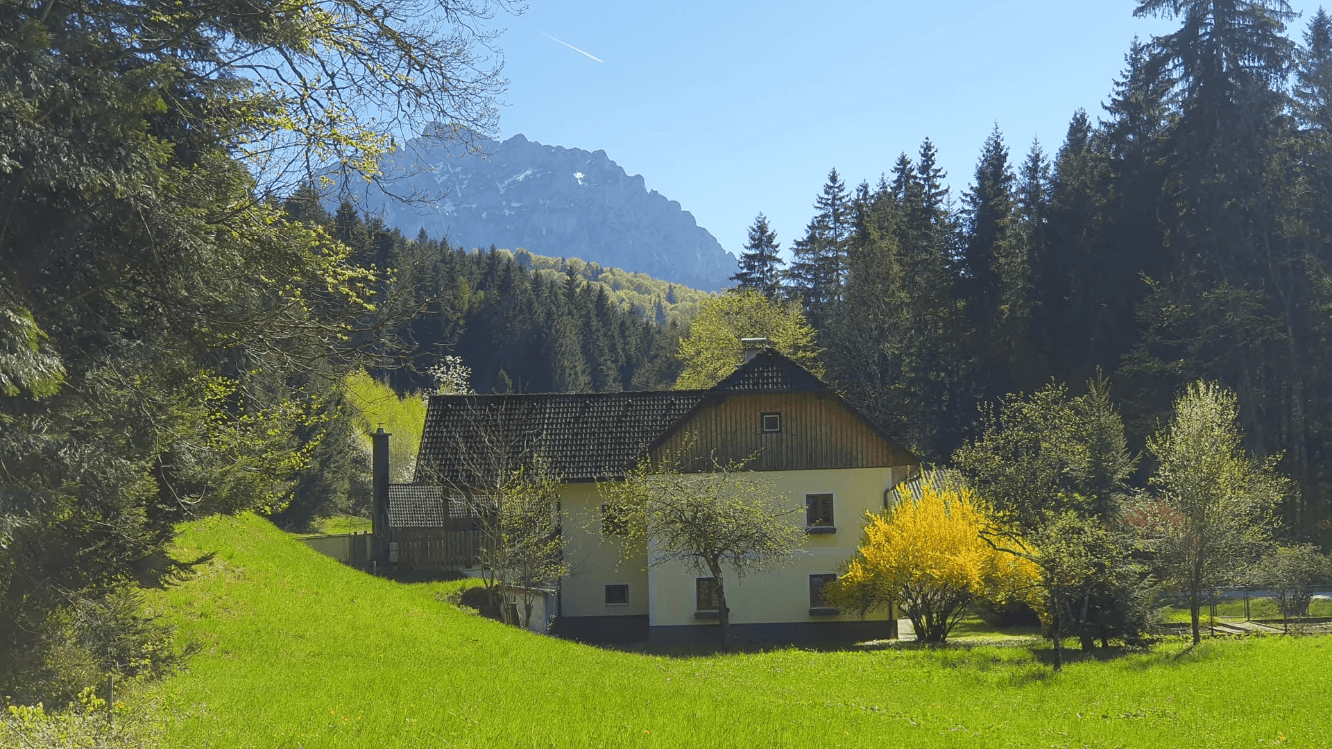 Idyllisches Landhaus in grüner Landschaft mit beeindruckendem Bergblick.