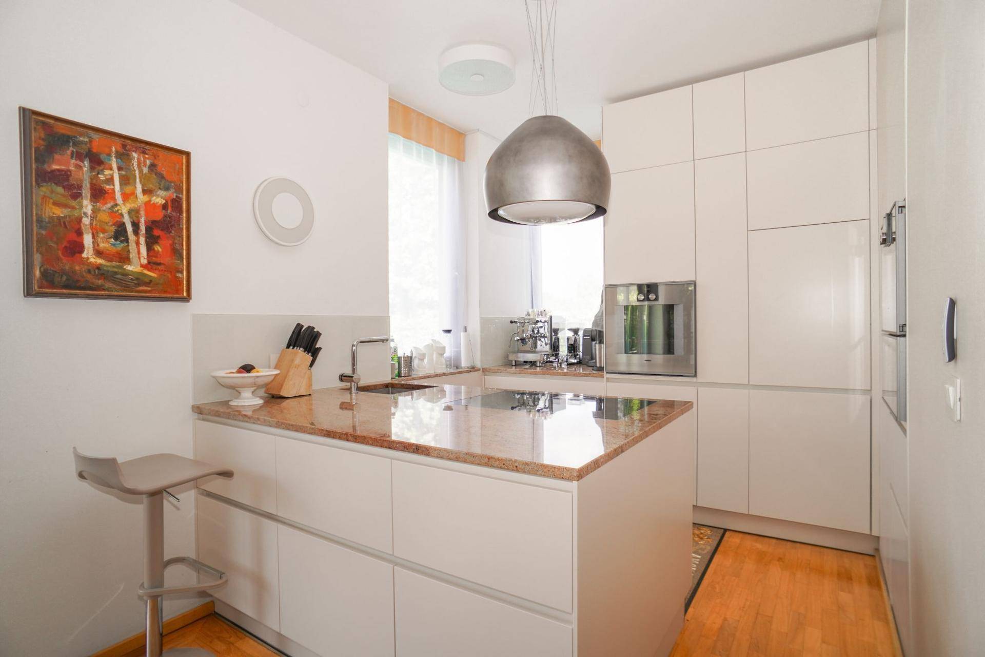 Moderne Küche mit Kücheninsel, Granitarbeitsplatte und integrierten Geräten.