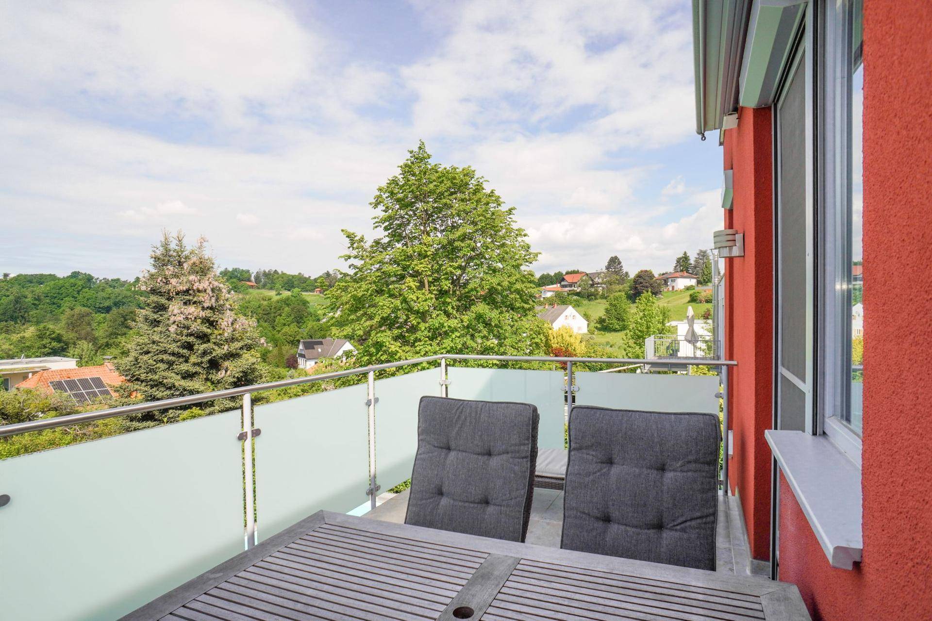 Geräumiger Balkon mit Tisch und Stühlen, bietet einen schönen Blick ins Grüne.