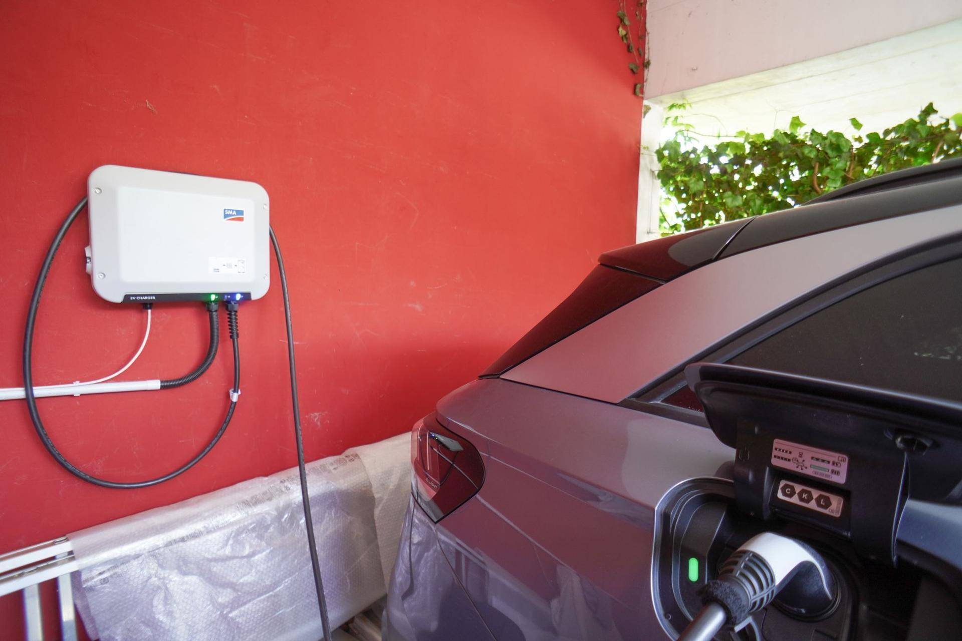 Ladestation für Elektrofahrzeuge im Carport des modernen Hauses.