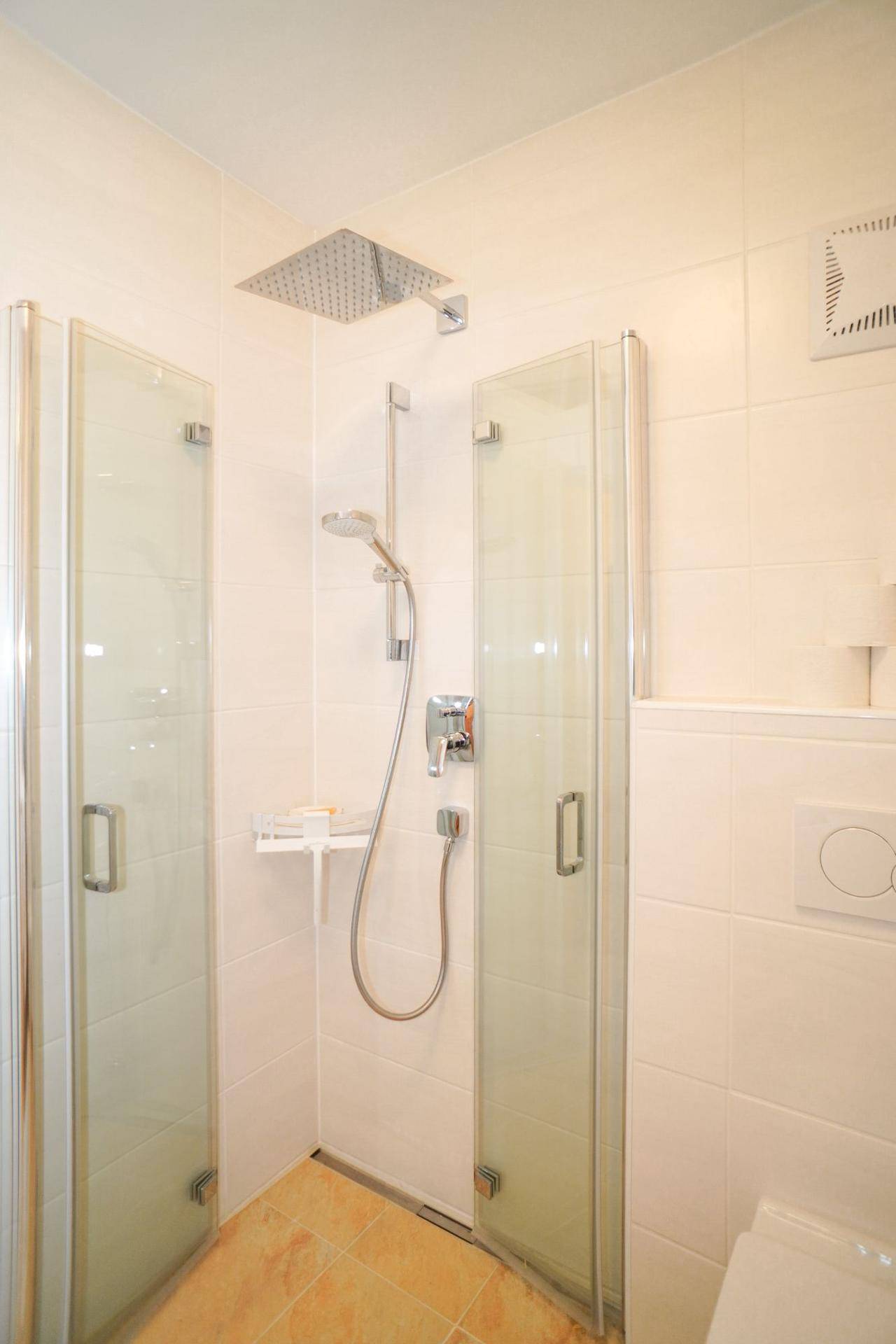 Duschbereich im modernen Badezimmer des Untergeschosses mit Regendusche.