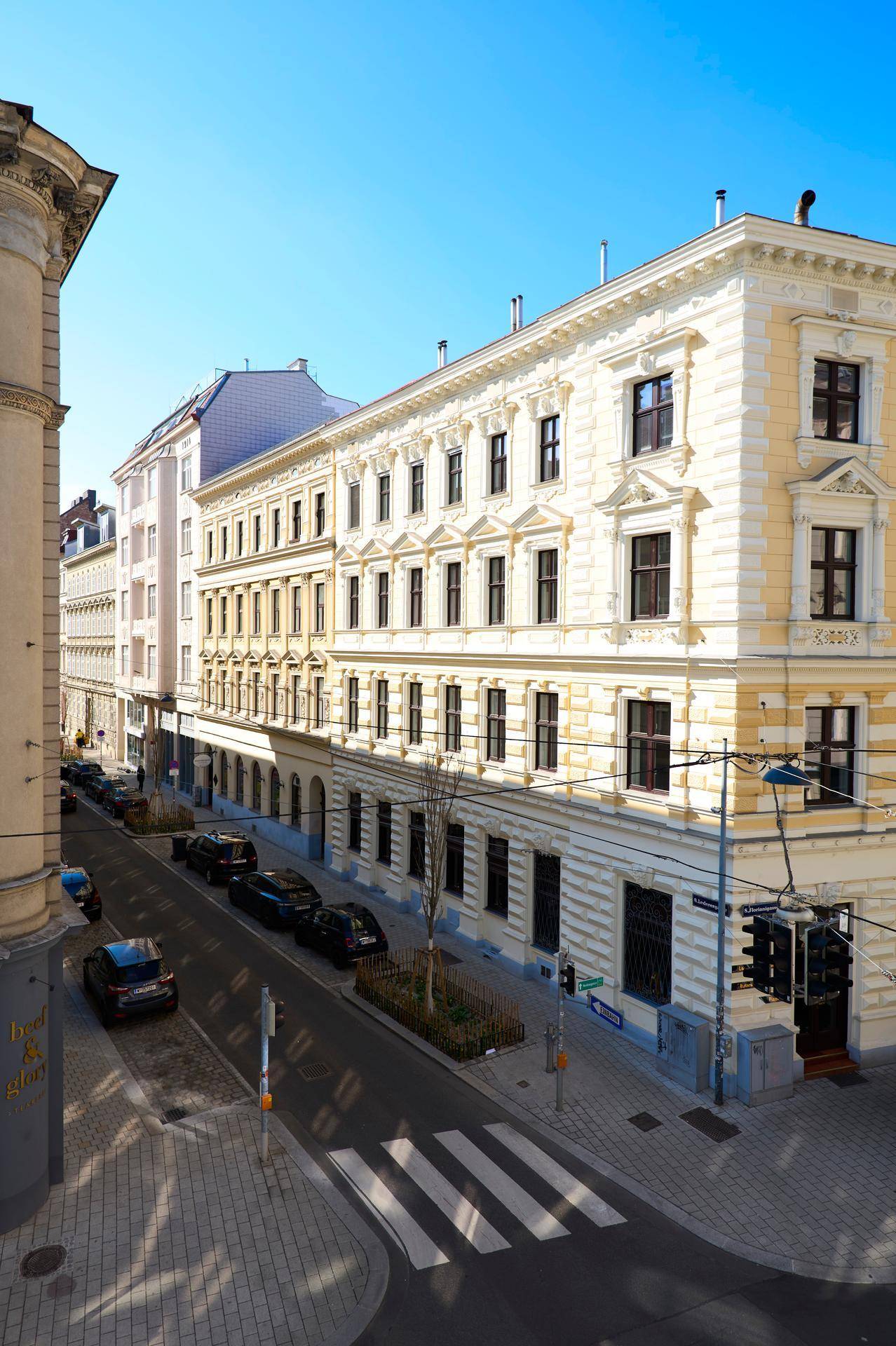 Historisches Eckgebäude mit klassischer Fassade und Blick auf die belebte Stadtstraße.