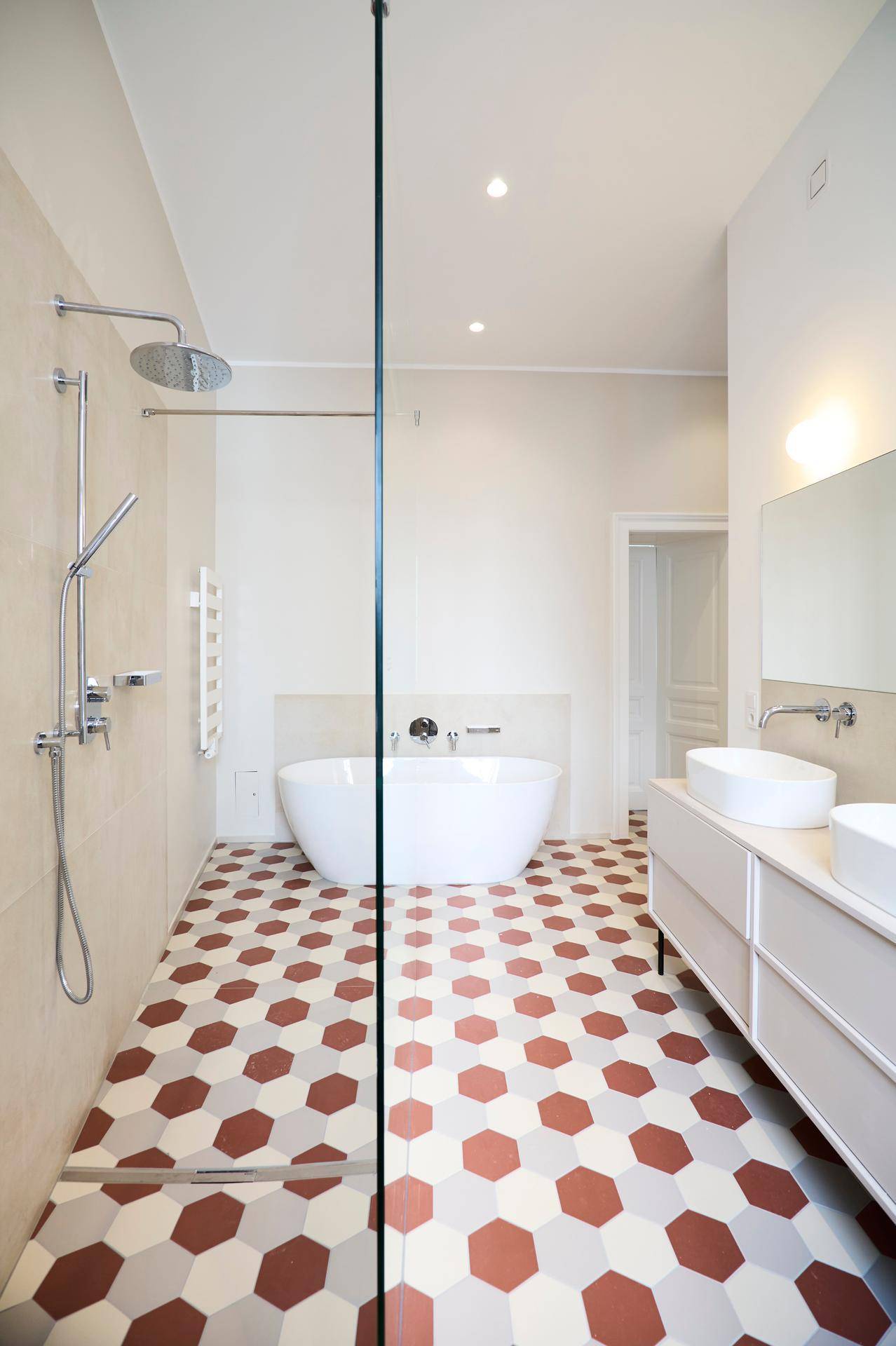 Großes Badezimmer mit freistehender Badewanne, begehbarer Dusche und Doppelwaschbecken auf einem modernen Waschtisch.