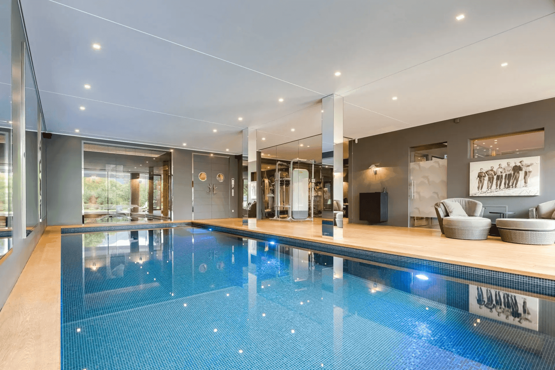 Luxuriöser Innenpoolbereich mit angrenzendem Fitnessraum und moderner Ausstattung.