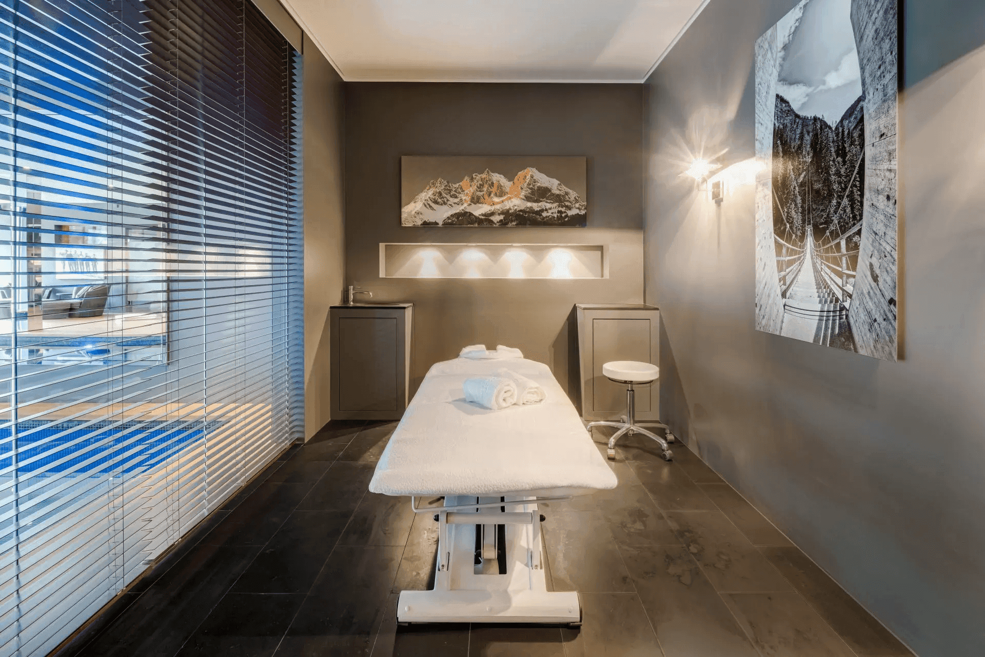 Entspannender Massageraum mit Liege und indirekter Beleuchtung im Wellnessbereich.