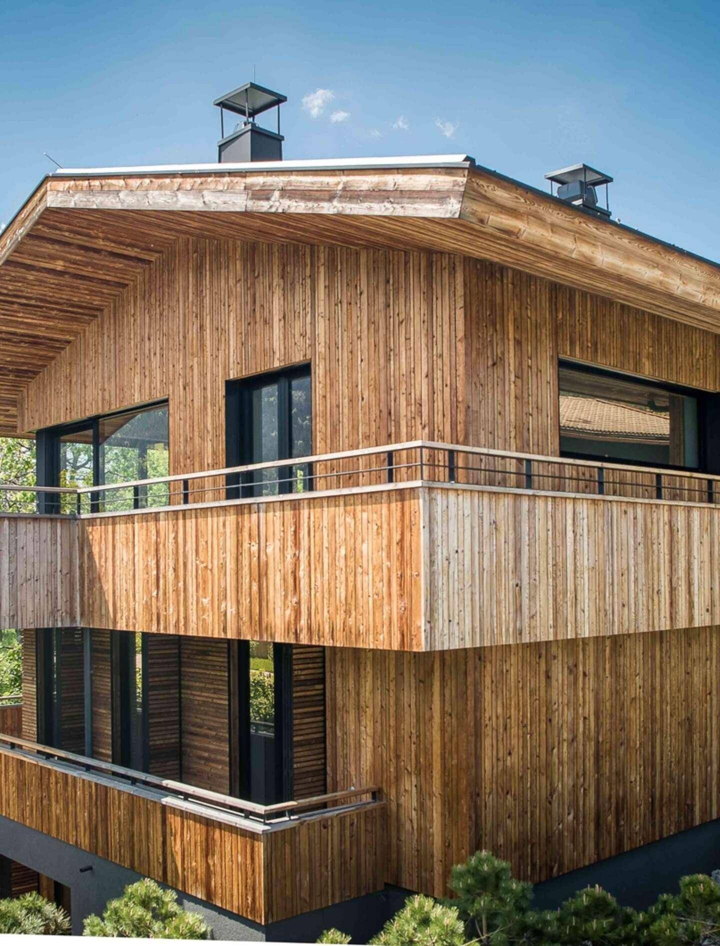 Detailansicht der Holzfassade mit vertikalen Lamellen und modernen Balkongeländern.