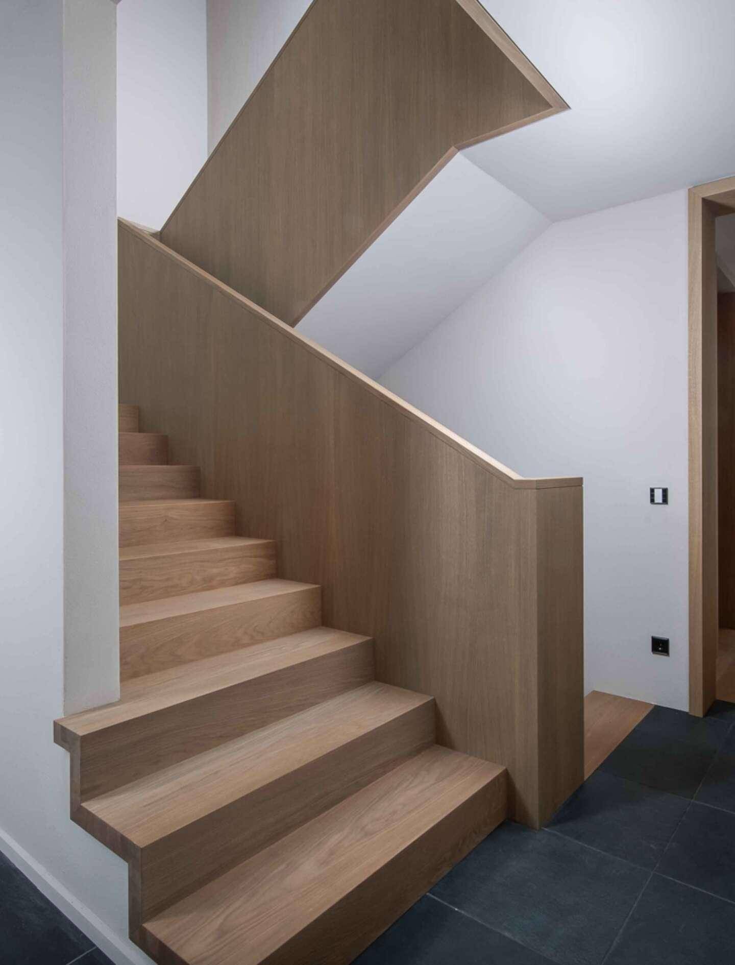 Moderne Holztreppe mit klaren Linien und minimalistischem Design, die die Etagen verbindet.