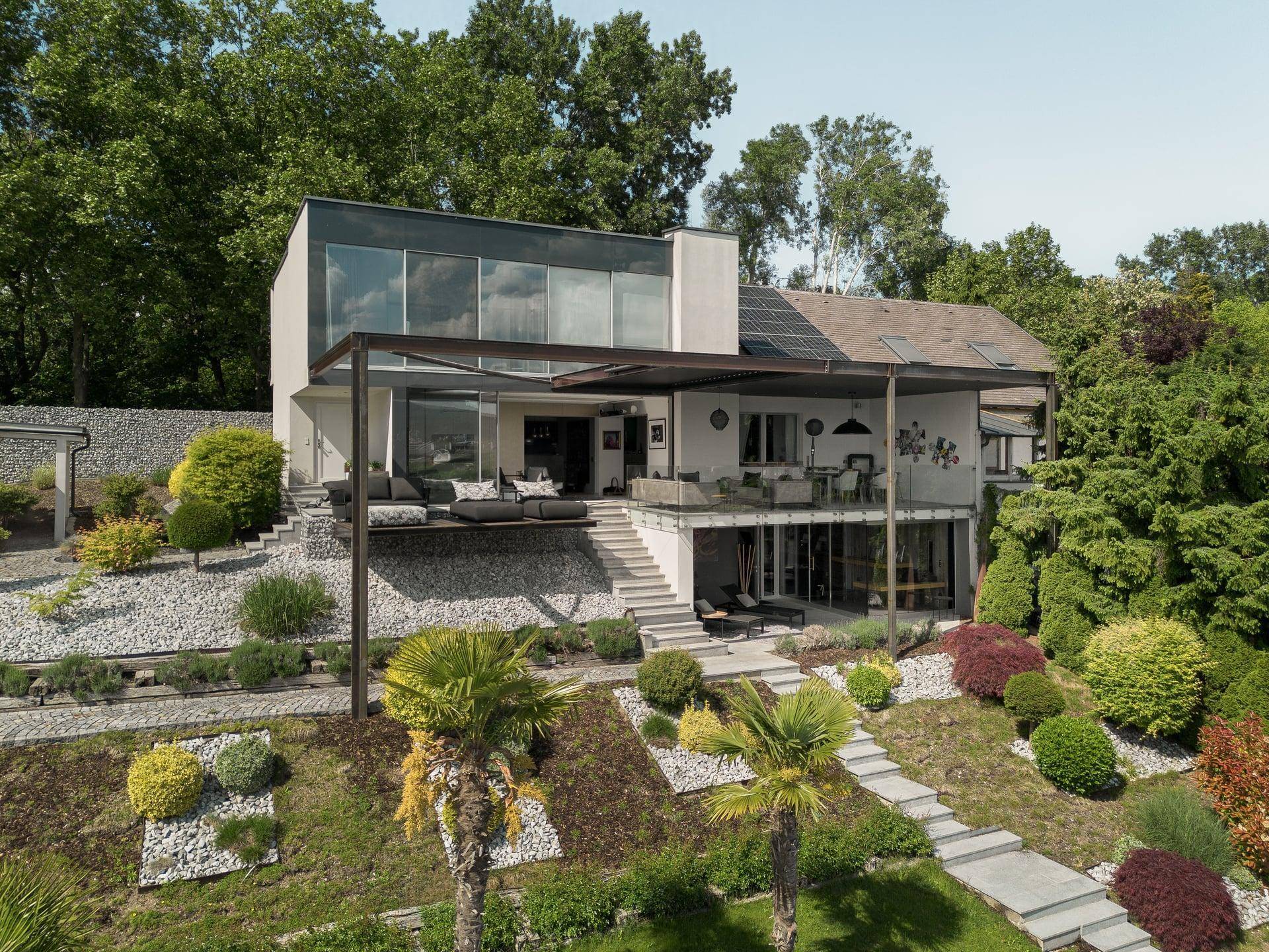 Luxuriöses Anwesen mit moderner Architektur, Terrassen und weitläufigem Garten mit Seeblick.