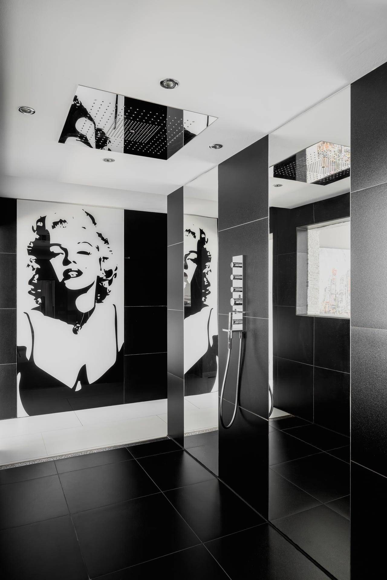 Moderne Duschkabine mit Regendusche und stilvoller Marilyn Monroe Wanddekoration.