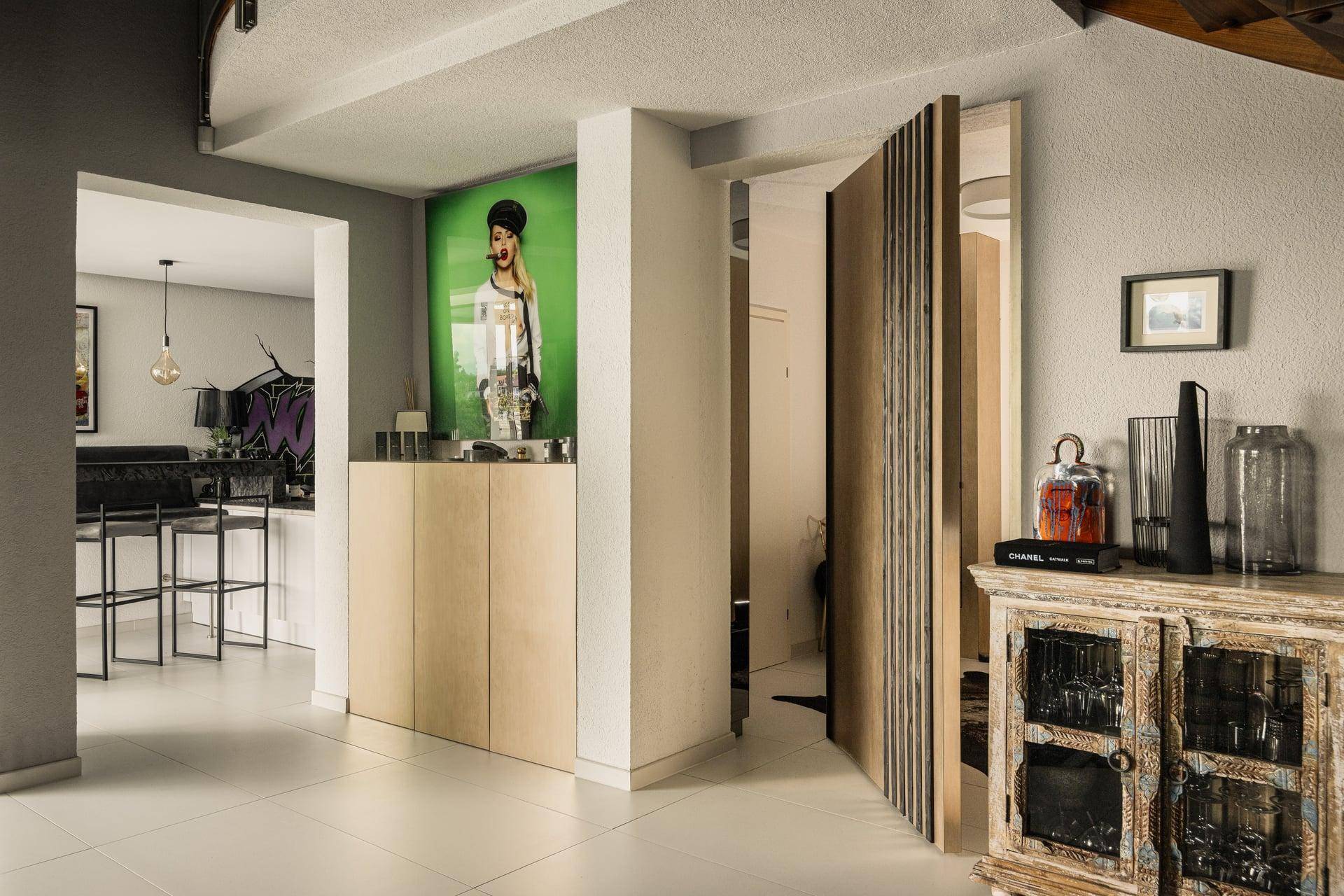 Heller Flur mit moderner Kunst, Holzelementen und Zugang zu weiteren Wohnbereichen.