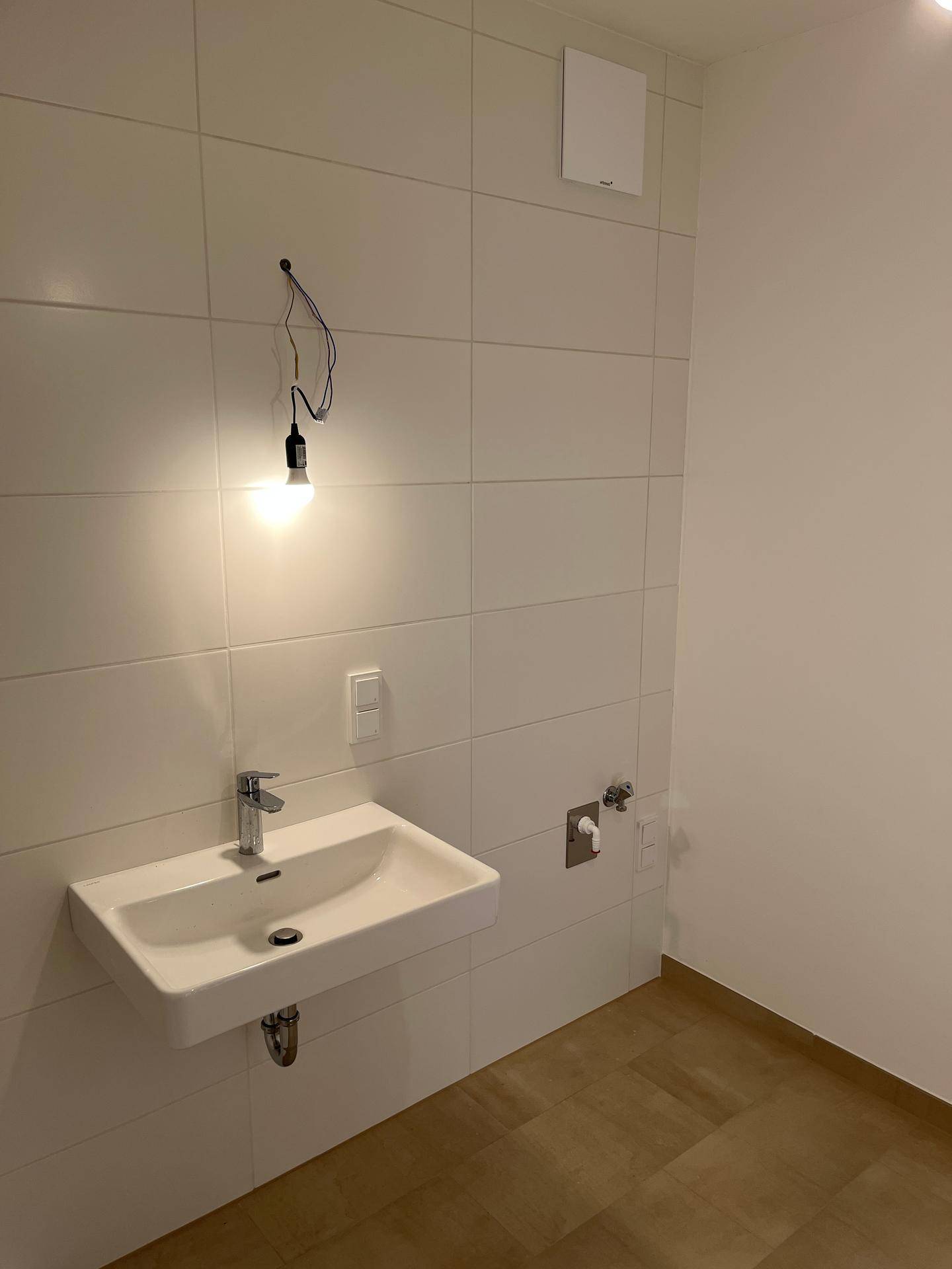 Helles Badezimmer mit modernem Waschbecken und weißen Fliesen, sauber und funktional.