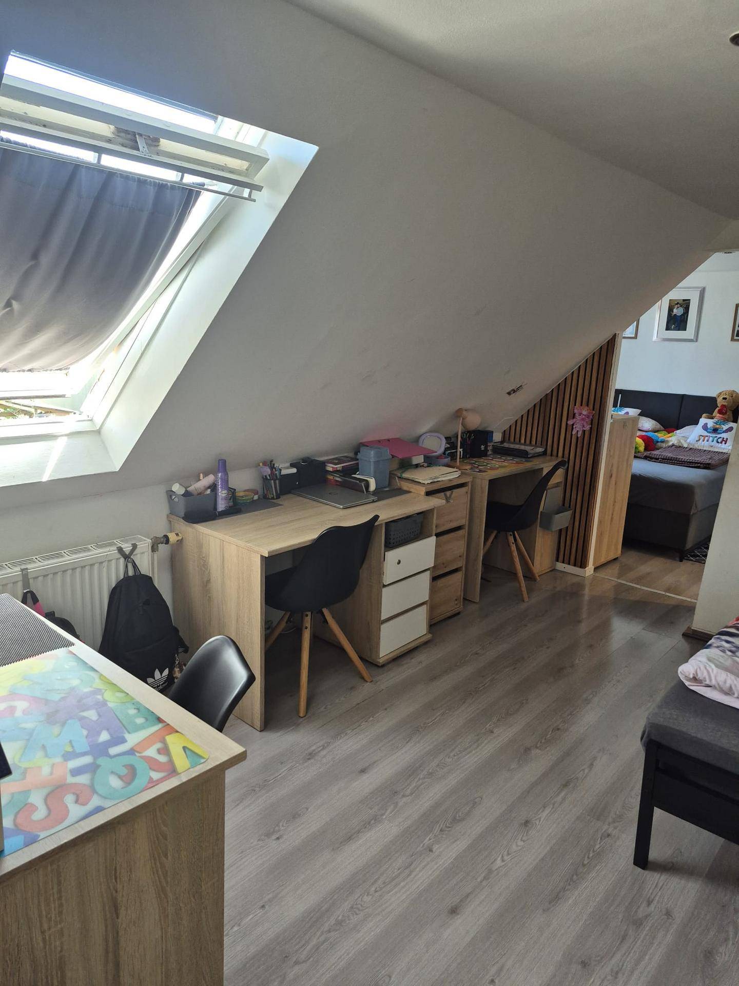 Arbeitsbereich im Dachgeschoss mit zwei Schreibtischen und einem großen Dachfenster für viel Licht.