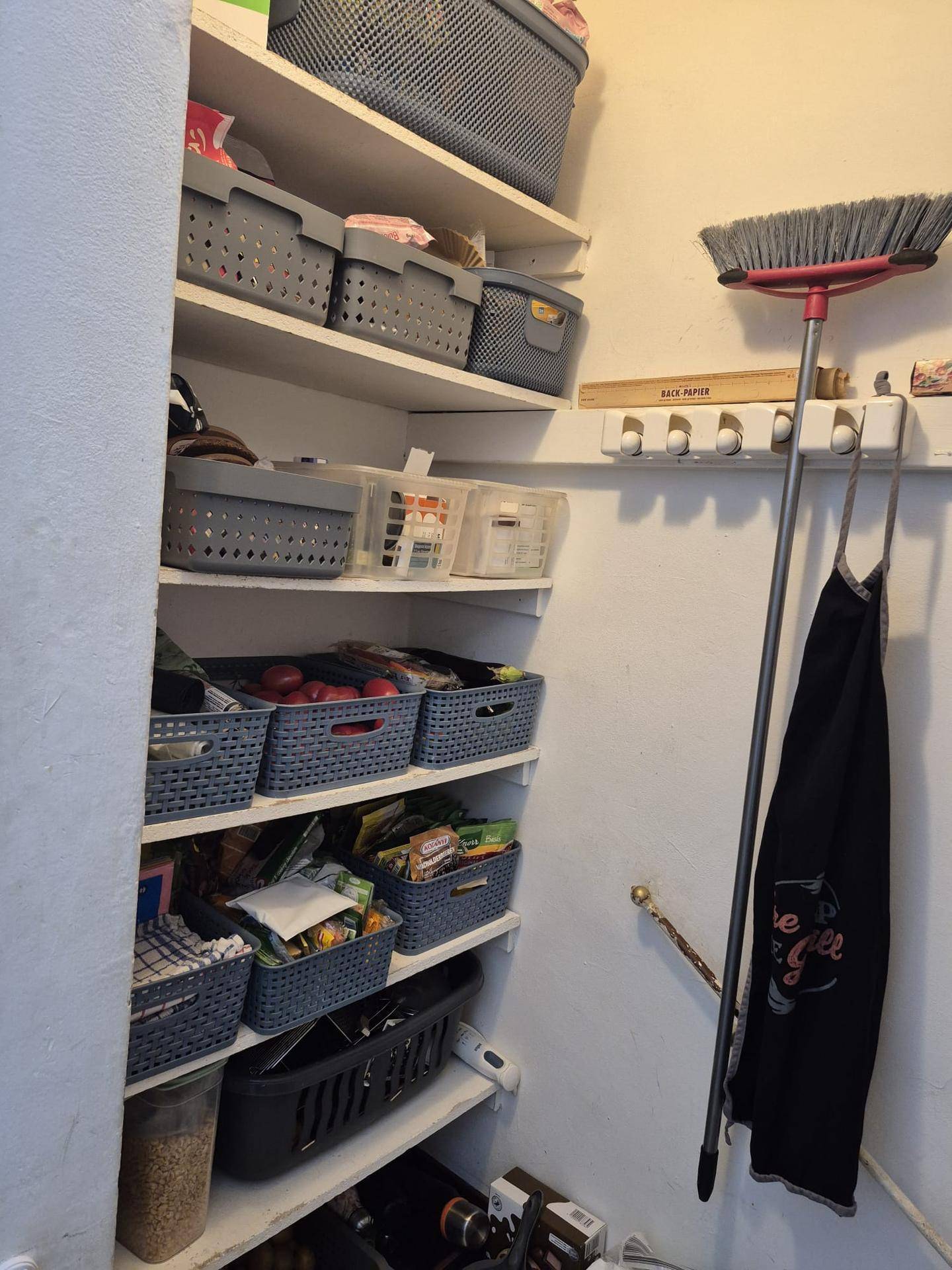 Praktischer Abstellraum mit Regalen und verschiedenen Haushaltsartikeln.