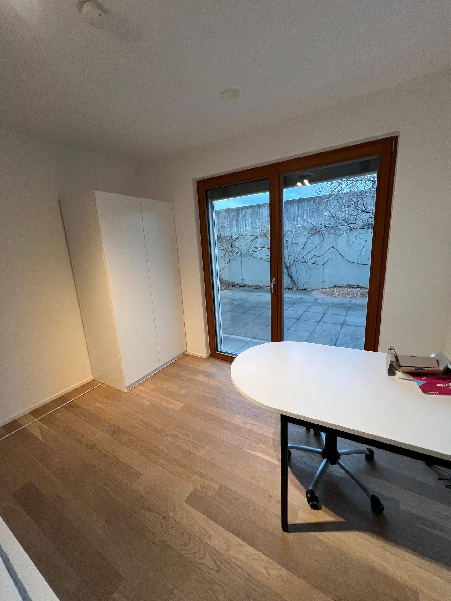 Ruhiges Arbeitszimmer mit Holzboden und direktem Zugang zur Außenterrasse.