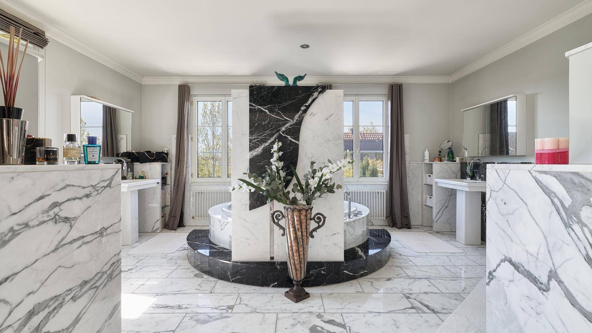 Luxuriöses Badezimmer mit Marmorfliesen, freistehender Badewanne und Doppelwaschbecken.