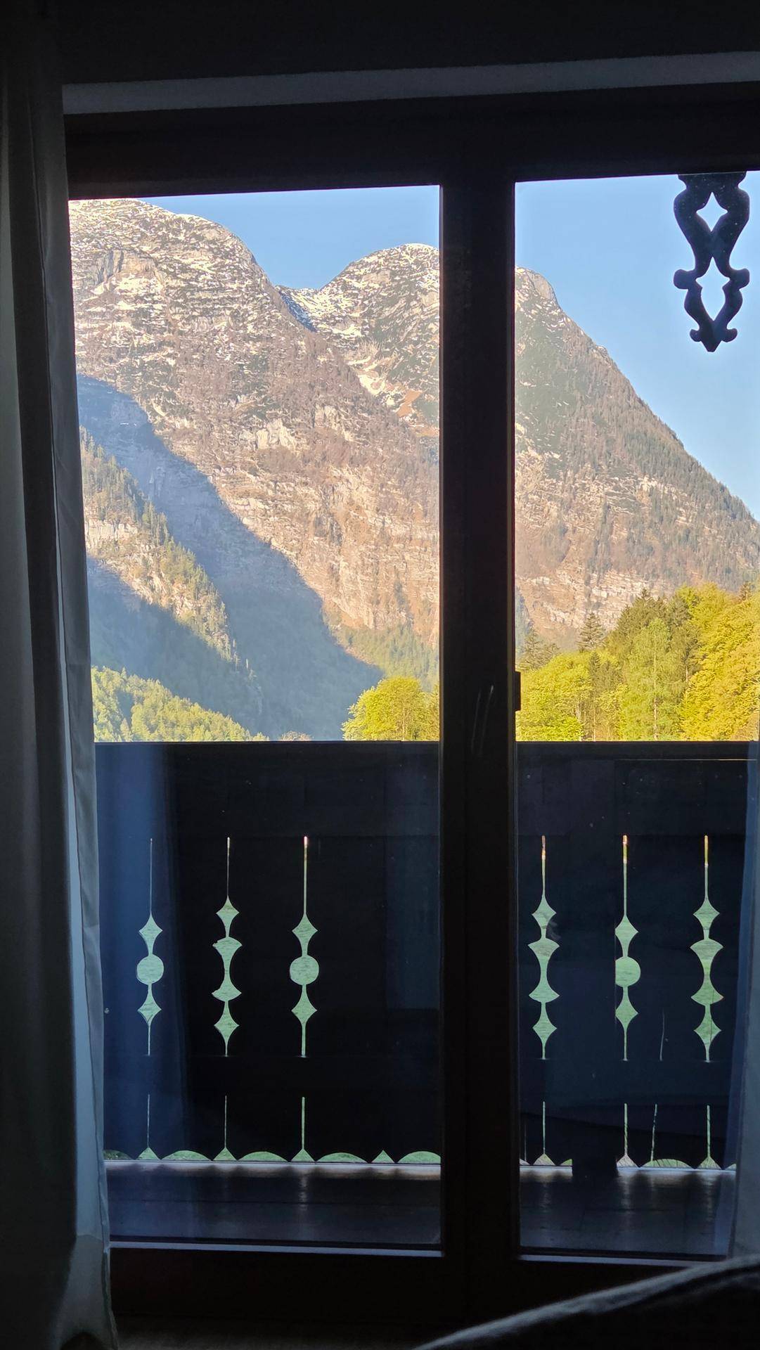 Atemberaubender Blick aus dem Fenster auf majestätische Berge und grüne Natur.