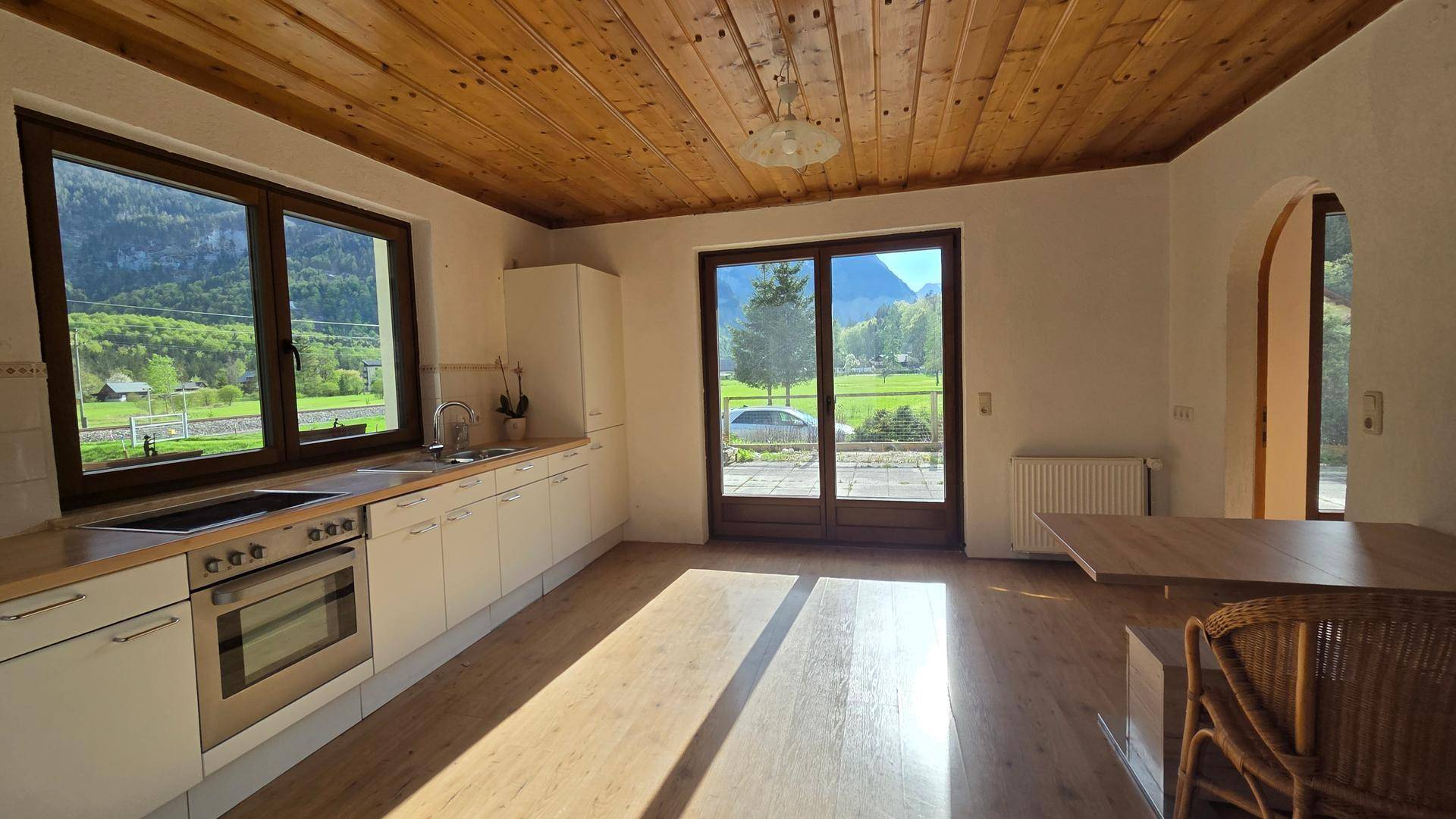Geräumige Küche mit Holzbalkendecke, Einbauküche und viel Tageslicht, ideal für kulinarische Erlebnisse.