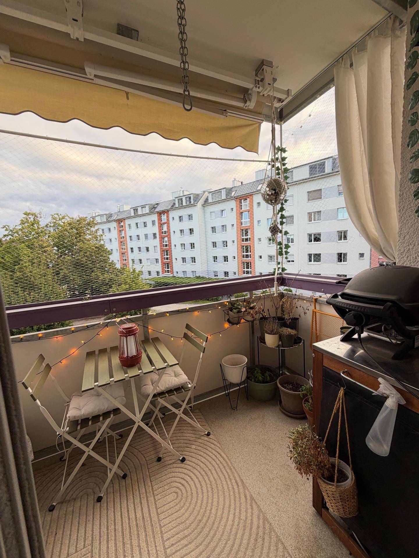 Balkon mit Grillbereich und gemütlichen Sitzgelegenheiten, ideal für entspannte Abende.
