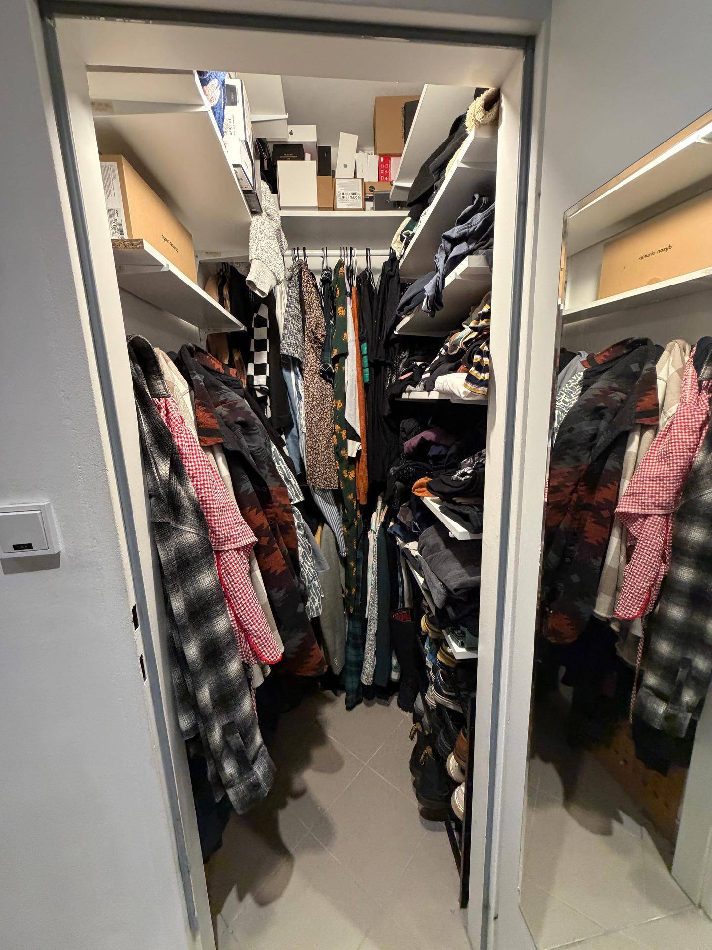 Praktischer begehbarer Kleiderschrank mit Regalen und viel Stauraum.