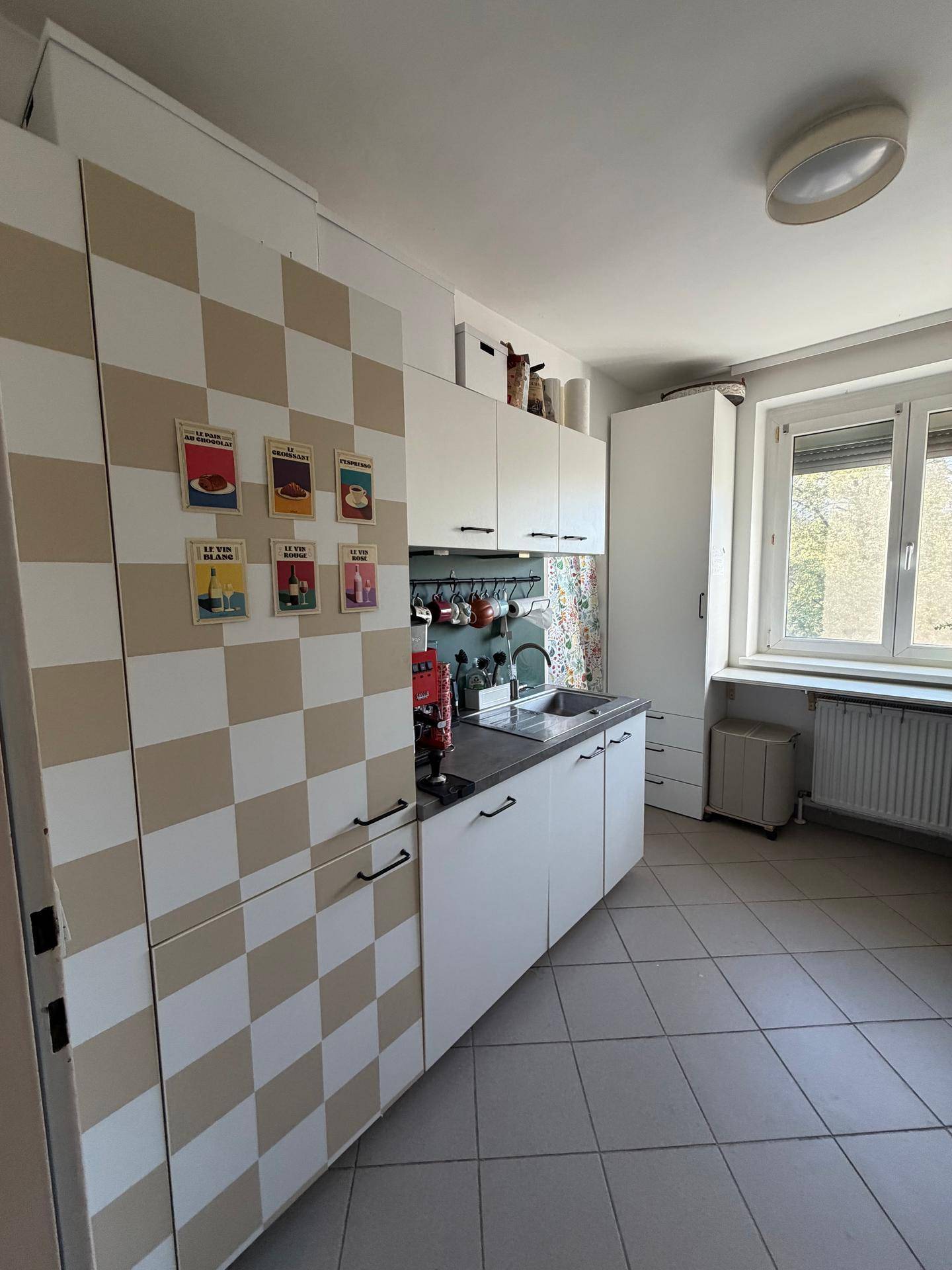 Moderne Küche mit weißen Schränken, Spüle und ausreichend Arbeitsfläche.