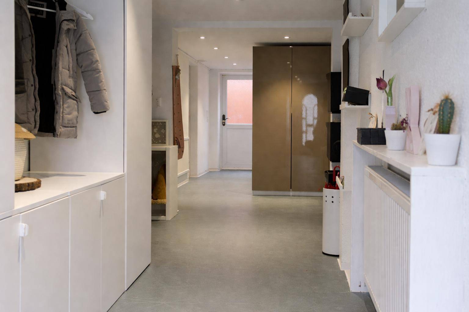 Heller Eingangsbereich mit Garderobe, Einbauschränken und modernem Bodenbelag.