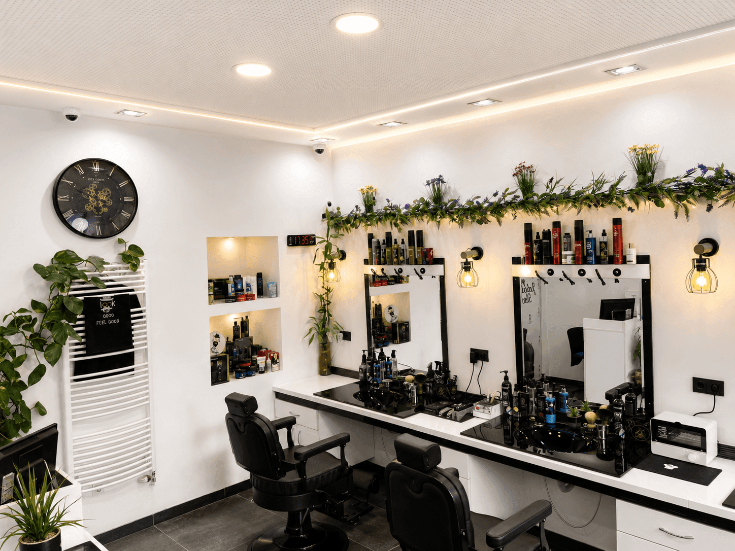 Innenansicht des Friseursalons mit Wandregalen, Produkten und einer großen Wanduhr als Dekoration.