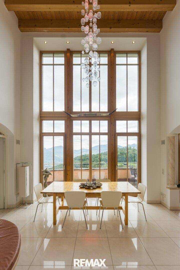 Beeindruckender Essbereich mit hohen Decken, großen Fenstern und Panoramablick auf die Berge.