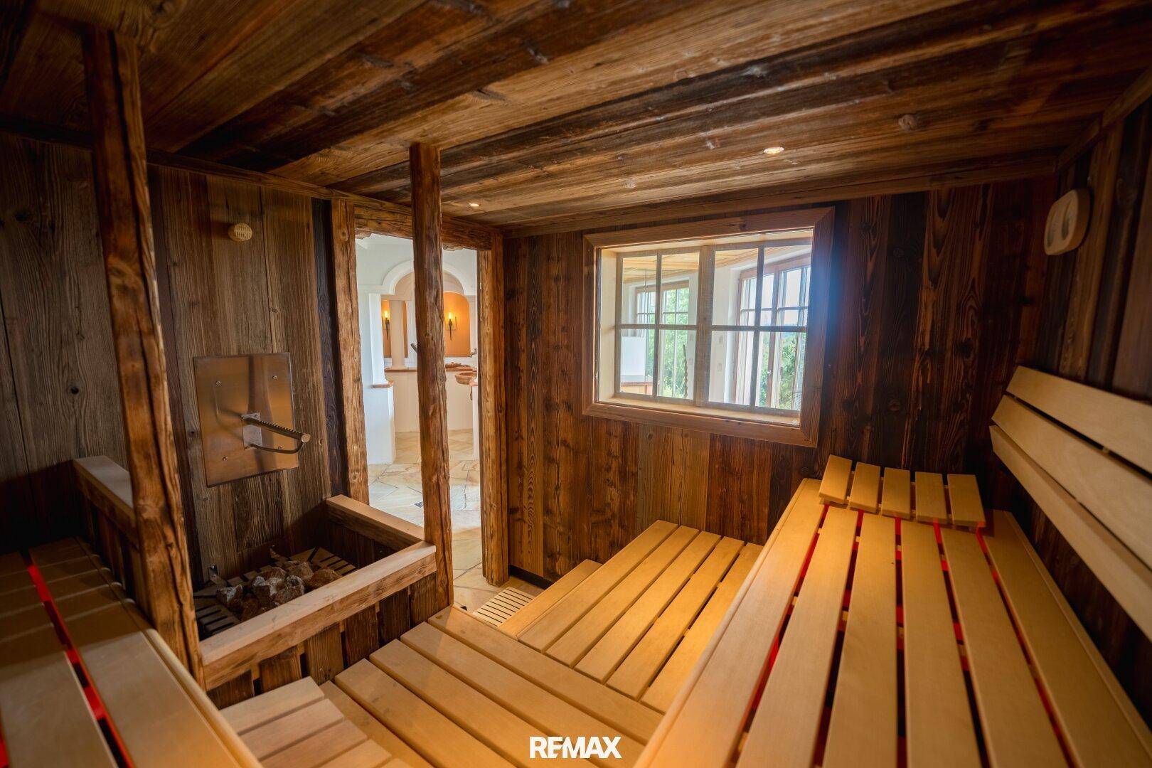 Traditionelle Holzsauna mit Bänken und einem Fenster, das für natürliche Belüftung sorgt.