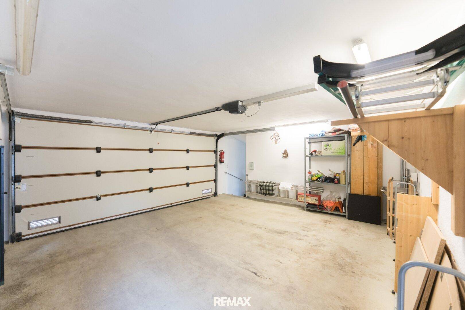 Geräumige Garage mit automatischem Tor und ausreichend Platz für Fahrzeuge und Lagerung.