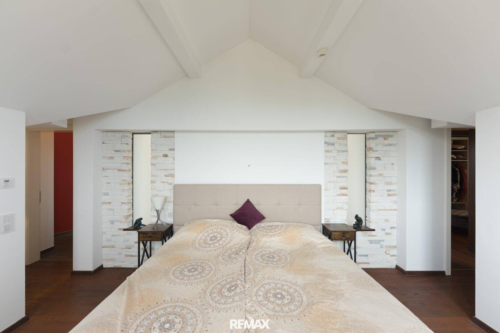Gemütliches Schlafzimmer im Dachgeschoss mit schrägen Wänden und modernem Design.