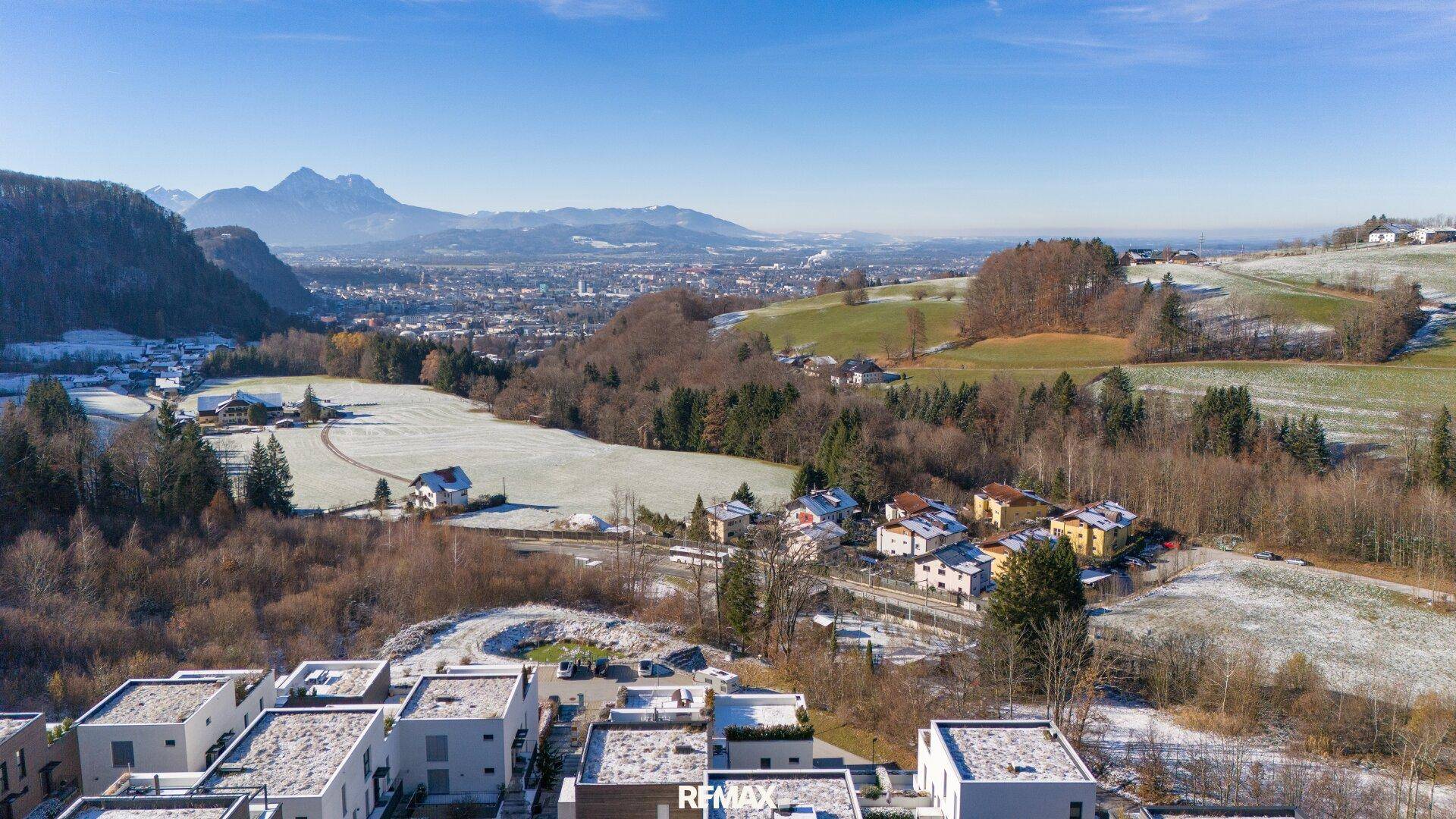 Panoramablick über die ländliche Umgebung mit verschneiten Feldern und einer Stadt in der Ferne.