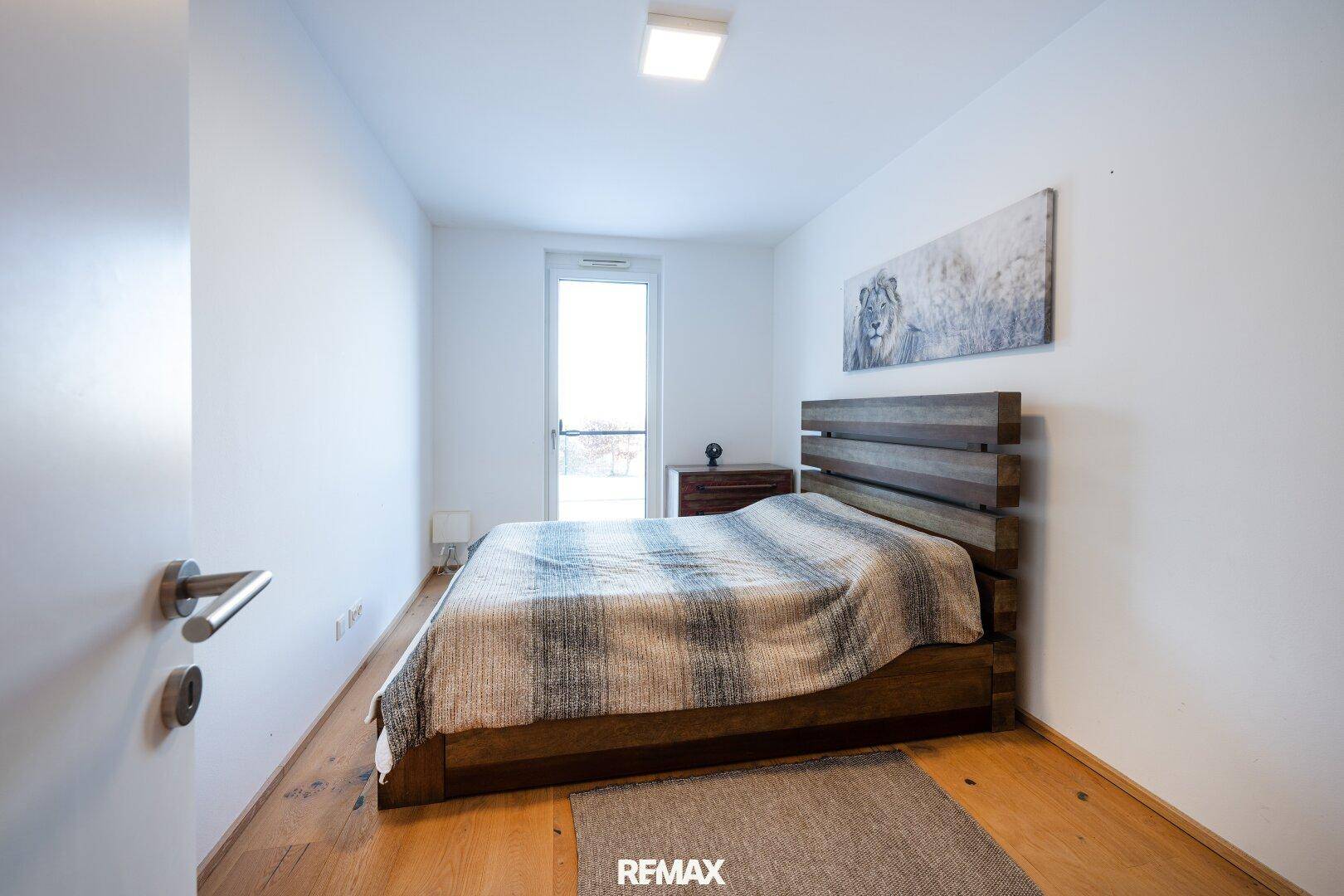 Gemütliches Schlafzimmer mit Holzboden, Holzbett und schlichtem, modernem Dekor.