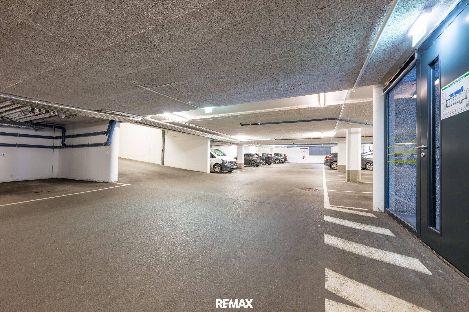 Geräumige Tiefgarage mit mehreren Parkplätzen und Zugang zum Gebäude.