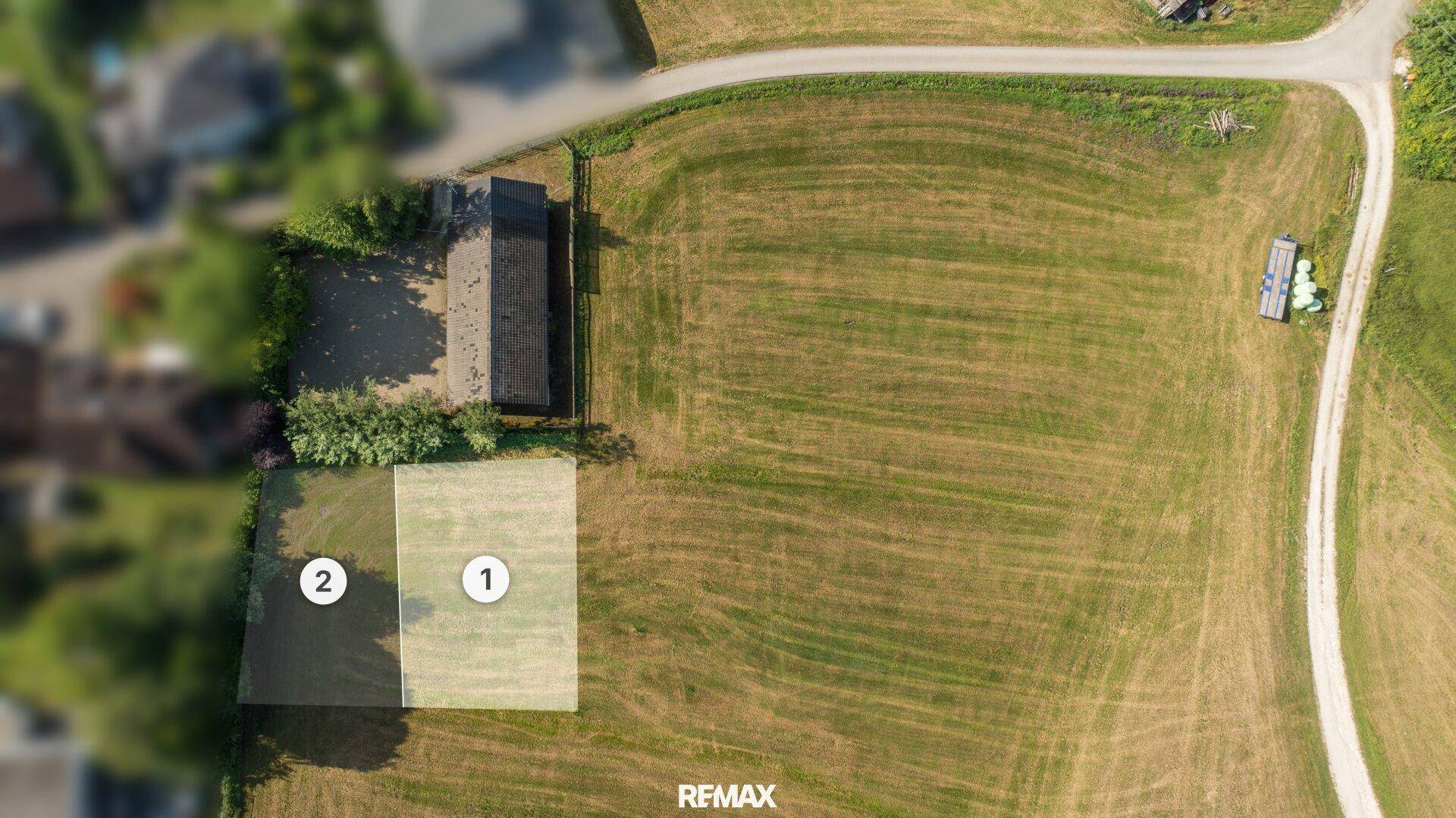 Übersicht aus der Vogelperspektive auf zwei Baugrundstücke in einer grünen Umgebung.