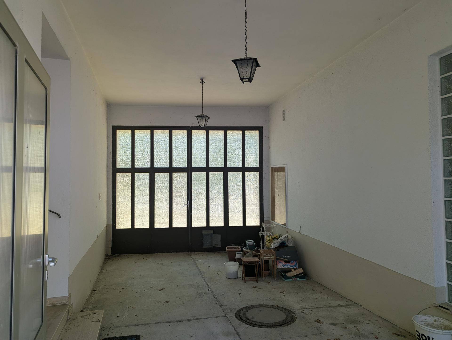 Geräumige Garage mit hohen Decken und großen Fenstertüren.