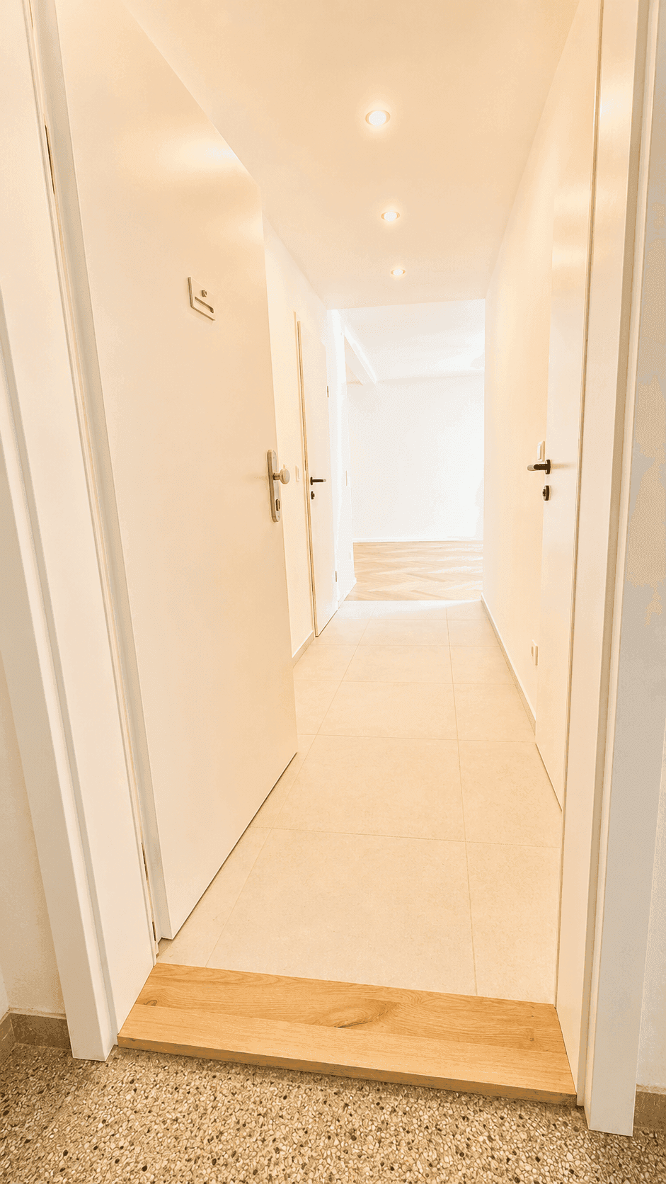 Langer, heller Flur mit Fliesenboden und Türen zu verschiedenen Räumen der Wohnung.