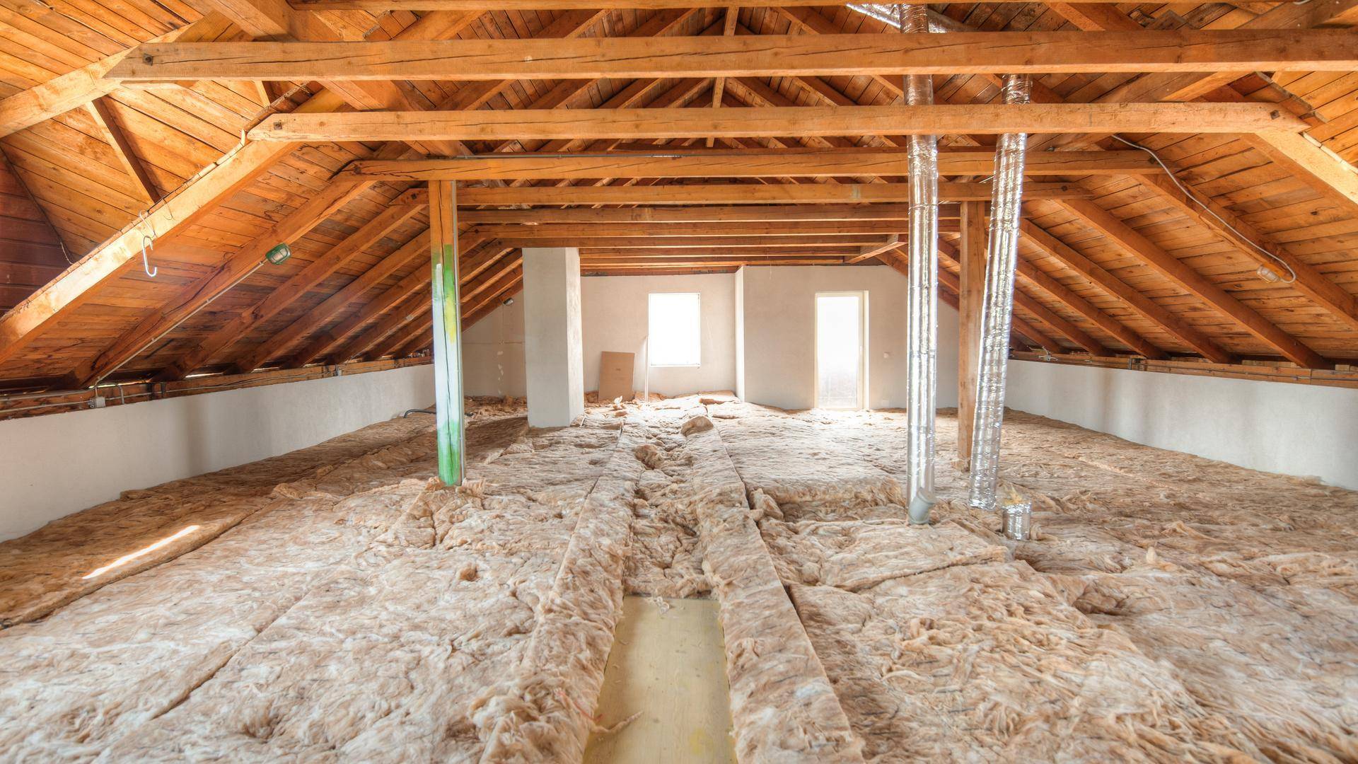 Unausgebauter Dachboden mit Holzdachstuhl und Fenstern, bietet viel Potenzial für zukünftige Nutzung.