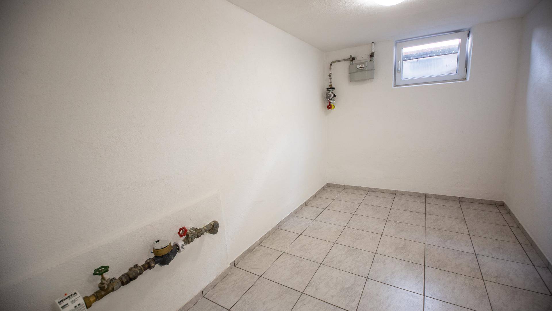 Kellerraum mit Fliesenboden, Zähler und kleinem Fenster, als Technikraum nutzbar.