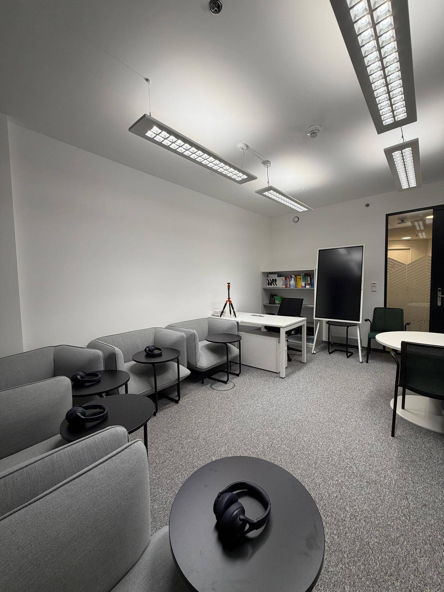 Gemütlicher Loungebereich in einem modernen Büro mit bequemen Sitzgelegenheiten und Teppichboden für entspannte Pausen.