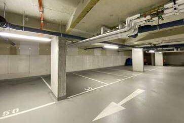Tiefgarage mit Betonpfeilern und markierten Stellplätzen für Fahrzeuge.