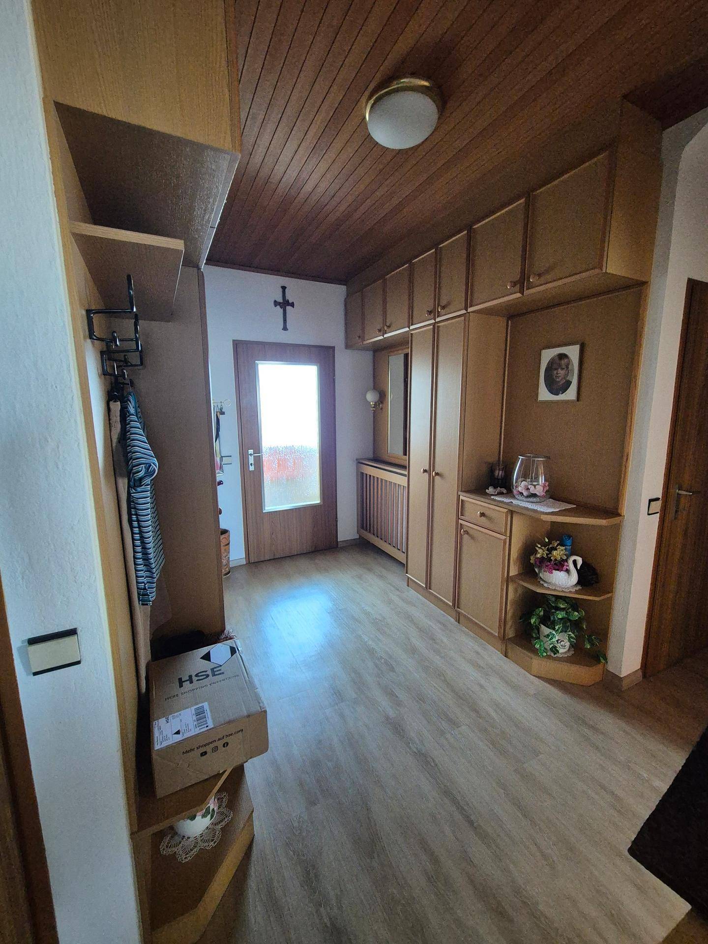 Eingangsbereich mit Holzdecke, Laminatboden und Einbauschränken für Stauraum.