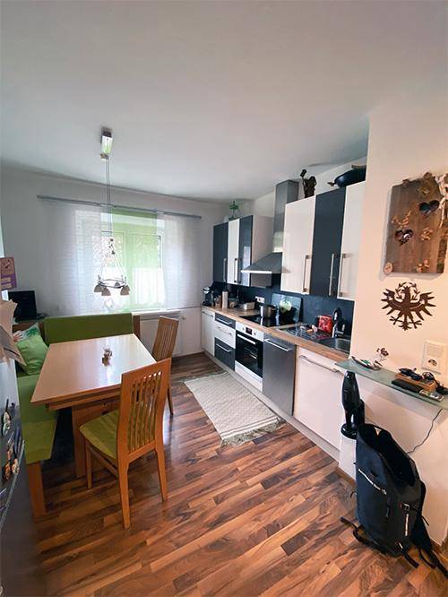 Funktionale Küche mit Essbereich, Holzfußboden und modernen Küchenschränken.