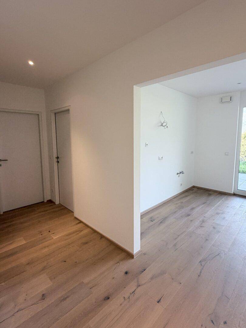 Geräumiger Flur mit hellem Eichenparkettboden und weißen Wänden, bietet Zugang zu weiteren Räumen.