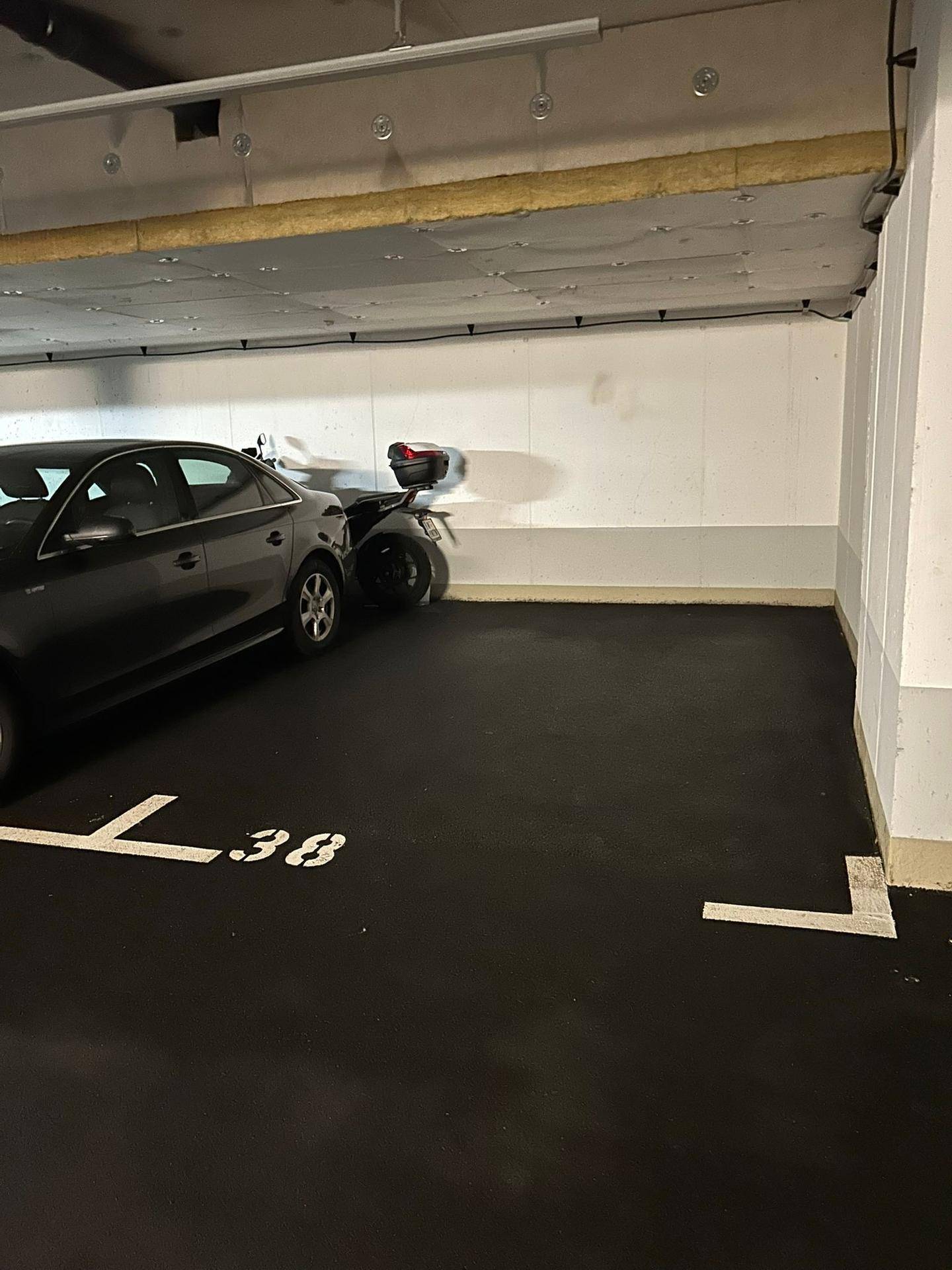 Geräumiger Tiefgaragenstellplatz 38 in einem gepflegten Zustand mit Betonwänden.
