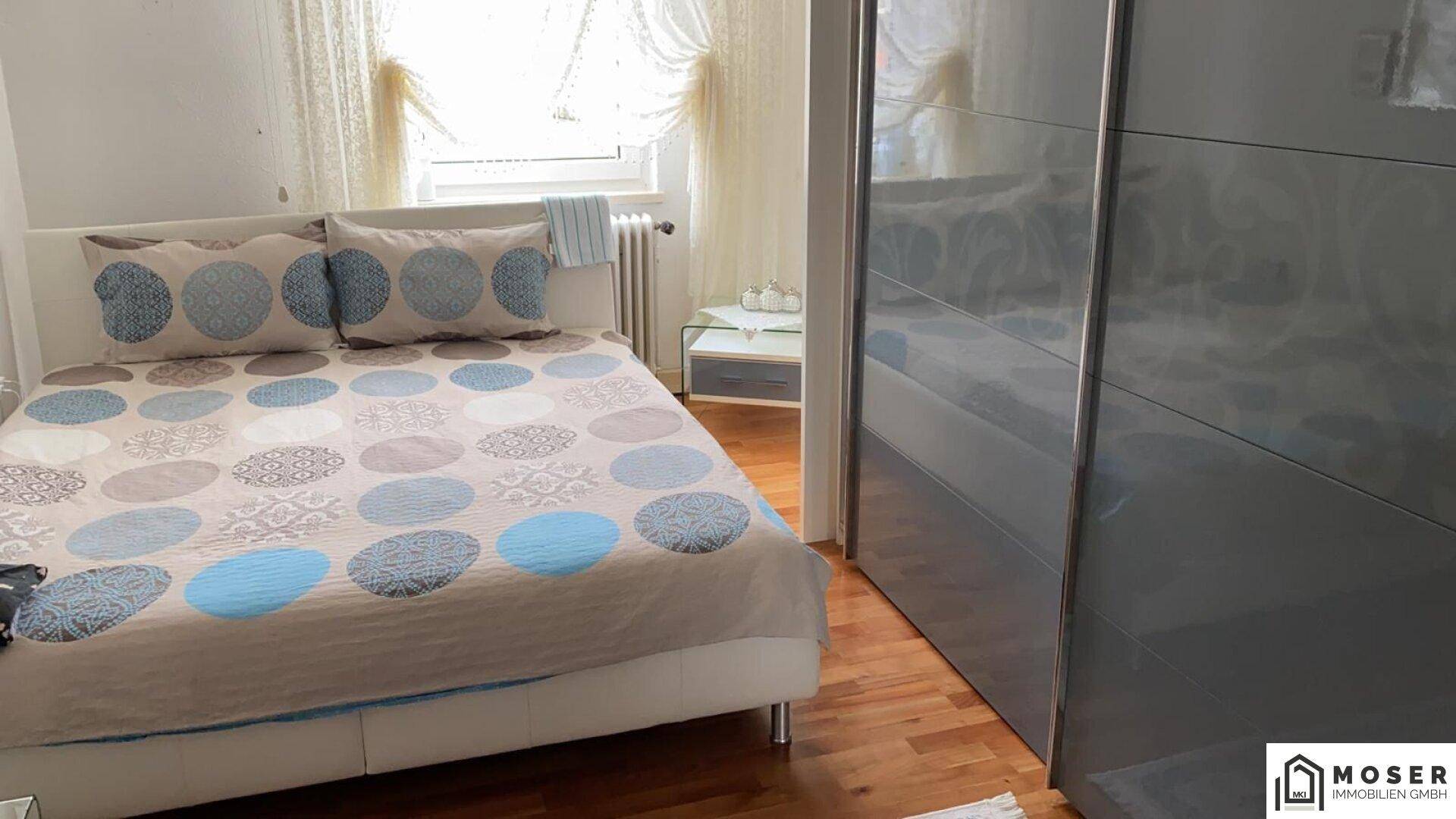 Gemütliches Schlafzimmer mit Doppelbett, großem Kleiderschrank und Holzboden.